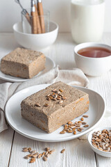 Halva with sunflower seeds close-up on a light background.