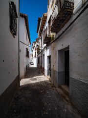 narrow street in the old town of Granada with Old Albaicin buildings, Spain
