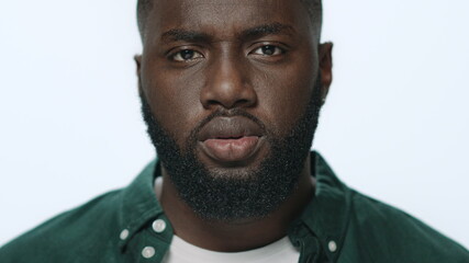 Portrait of thoughtful african american guy looking at camera in studio.