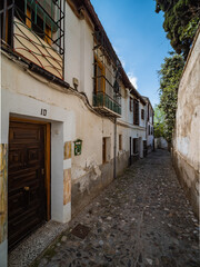 Fototapeta na wymiar narrow street in the old town of Granada with Old Albaicin buildings, Spain