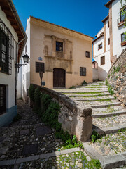 narrow street in the old town of Granada with Old Albaicin buildings, Spain