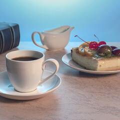 a cup of strong black coffee and a piece of delicious homemade cake on a plate on a wooden table