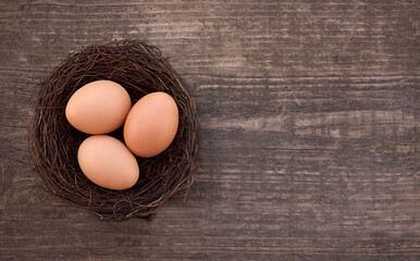 Nest of fresh farm eggs. Easter Basket with eggs on wooden background