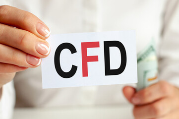 On the table are bills, a bundle of dollars and a sign on which it is written - CDF. Finance and economics concept.