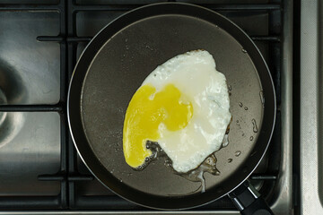 A frying pan with scrambled eggs is on the stove. Close-up