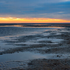 Naklejka premium Sonnenuntergang im Niedersächsischen Wattenmeer vor Cuxhaven Sahlenburg bei Ebbe, Deutschland