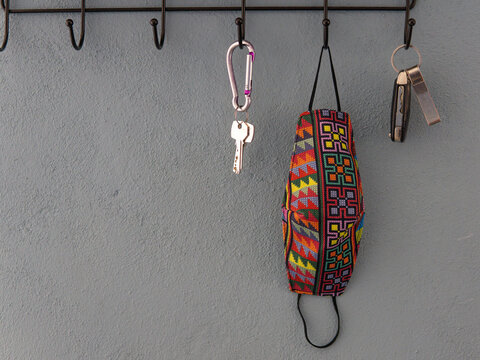 Cubrebocas y llaves colgando de un perchero, salir en pandemia.