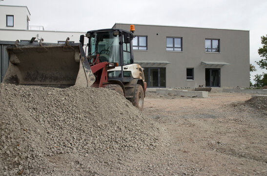 Kleiner Bagger baggert Kies auf einer Baustelle