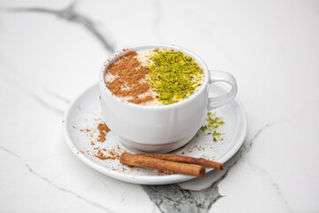 salep, sahlep, white cup Sahlep, Turkey's milk hot drink with cinnamon powder and antes Fist of autumn winter drink, marble background