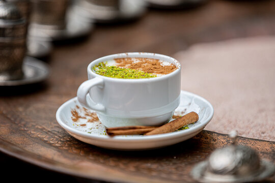 coffee, sahlep, white cup Sahlep, Turkey's milk hot drink with cinnamon powder and antes Fist of autumn winter drink, copper background