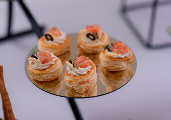 Close up view of portion small delicious snacks with trout and souce on the serving table on the party.
