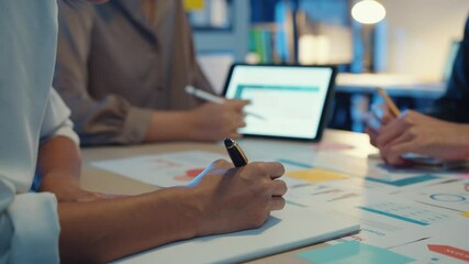 Group of Asia young creative people in smart casual wear discussing business brainstorming meeting ideas mobile application software design project in modern night office. Coworker teamwork concept.