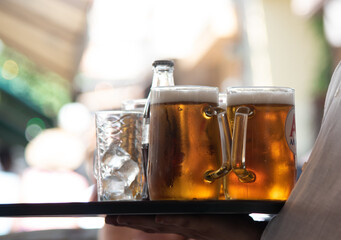 Waiter serving gold refreshing beer in a bar. Alcoholic refreshment drink