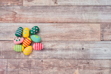 Colorful painted Easter eggs on brown wooden background.