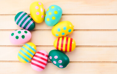 Fototapeta na wymiar Colorful painted Easter eggs on brown wooden background.