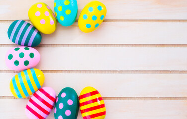 Colorful painted Easter eggs on brown wooden background.