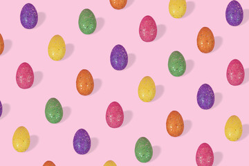Creative Easter pattern made of colorful eggs arranged on bright blue background.