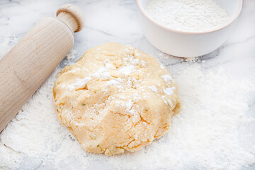 Fresh dough with a rolling pin and flour