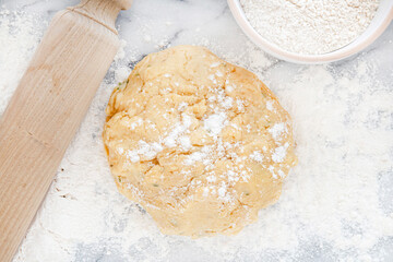 Fresh dough with a rolling pin and flour