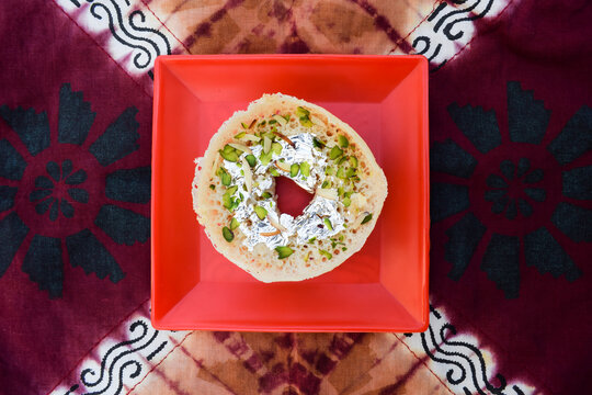 Traditional Indian festival dessert sweet Ghewar. unique different from India rajasthan eated during festivals like holi. with decorative background