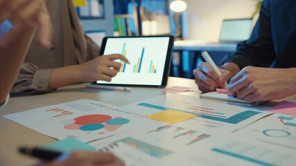 Group of Asia young creative people in smart casual wear discussing business brainstorming meeting ideas mobile application software design project in modern night office. Coworker teamwork concept. - Powered by Adobe