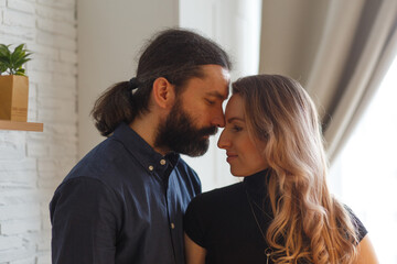 Man embracing pregnant partner in kitchen.