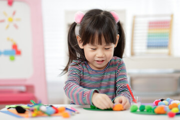 young girl hand makes caterpillar craft for home schooling