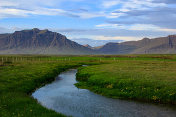 Fototapeta premium Stream and meadow with distant mountain range, Snaefellsnes peninsula, Iceland