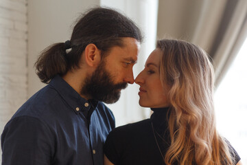 Man embracing pregnant partner in kitchen.