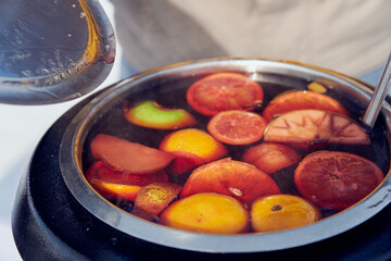 mulled wine in a pot. apple, lemon, orange, grapefruit ingredients 
