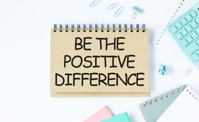 Be the positive difference text on notepad on white table.
