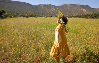 Girl with wreath on head in the field.