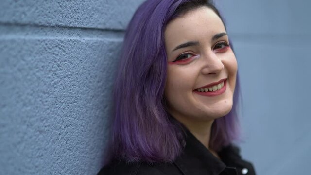 Chica con pelo morado interactuando con el smartphone y con la lluvia