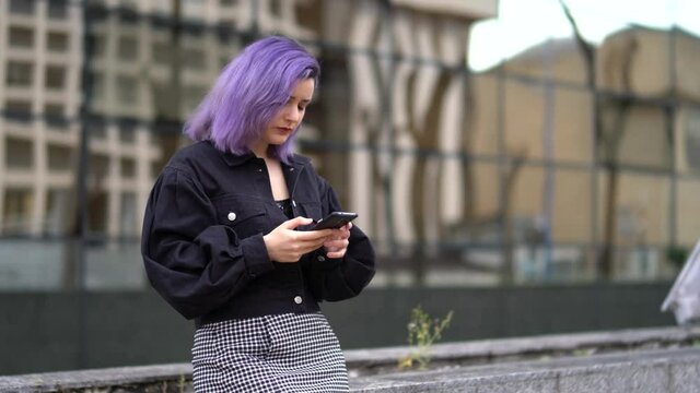 Chica con pelo morado interactuando con el smartphone y con la lluvia