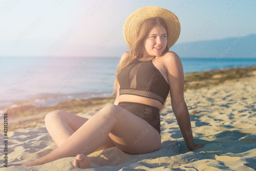 Wall mural cheerful plus size teenage girl wearing hat enjoying the beach. smiling, happy, positive emotion, su