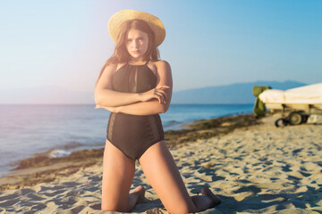 Cheerful plus size teenage girl wearing hat enjoying the beach. smiling, happy, positive emotion, summer style.