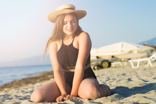 Cheerful plus size teenage girl wearing hat enjoying the beach. smiling, happy, positive emotion, summer style.