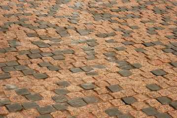 Detail of granite street paving stones in gray and brown colors.