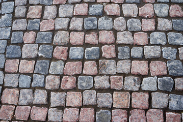 Detail of granite street paving stones in blue and brown colors.