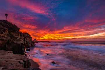 Dramatic fiery colorful sunset over crashing pacific ocean waves in La Jolla San Diego California  © Ashwin