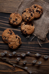 Morning breakfast vanilla muffins in white paper cups on a beautiful towel, close-up. Wooden background. 