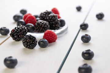 blueberries, raspberries and blackberries on white background