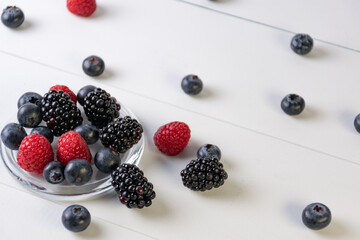 blueberries, raspberries and blackberries on white background