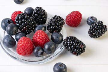 blueberries, raspberries and blackberries on white background