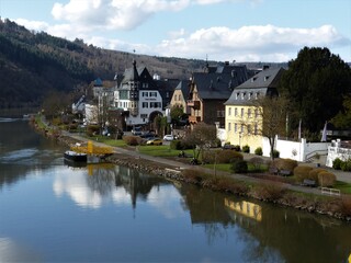Fototapeta na wymiar Blick von der Moselbrücke auf die Häuserzeile an der Mosel mit Landschaften in Traben-Trarbach 