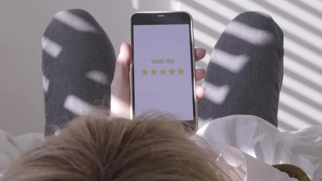 Woman rating app. five-star rating using a smartphone application. Close-up of a person Giving a 5 stars quality review on a Rate my experience app on a smartphone. 
using smartphone