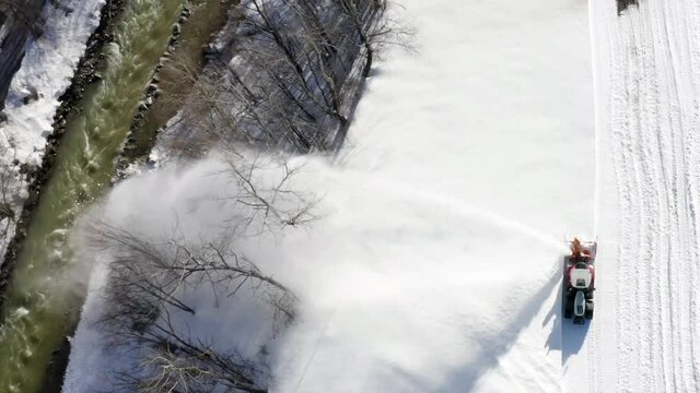 Snow thrower is cleaning the football field from snow. Bird's eye view.
