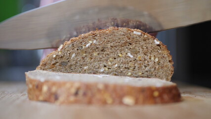 Slicing Whole Grain Bread On Wooden Table.