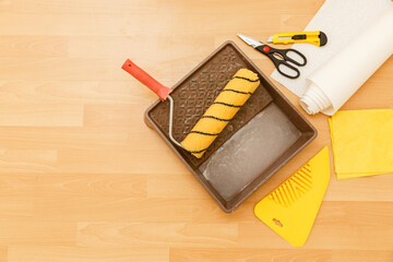 Tools for gluing wallpapers on the laminate floor. A room after renovation. Fresh repair in a room....