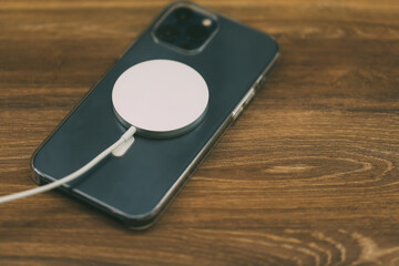 Charging with the new MagSafe wireless charger the latest iPhone 12 Pro Max 5G smartphone model by...